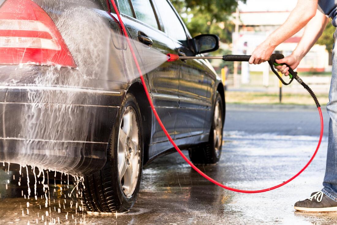 man power washing a car